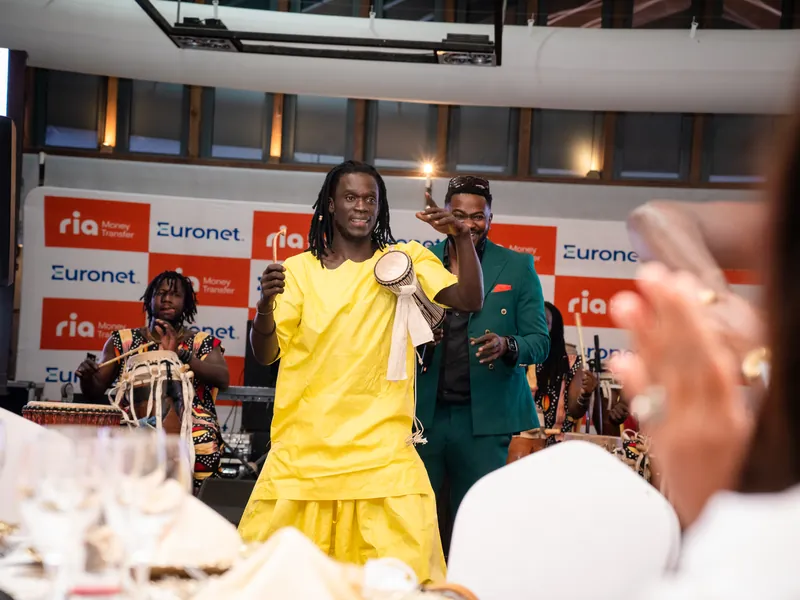Artiste en tenue jaune devant le photocall de la soirée