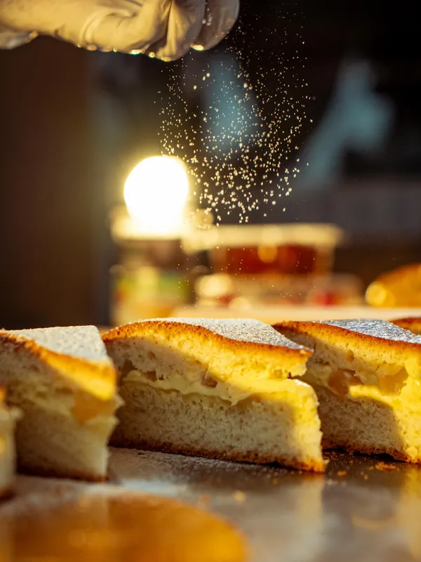 Sucre glace saupoudré sur des parts de gâteau, à contre-jour