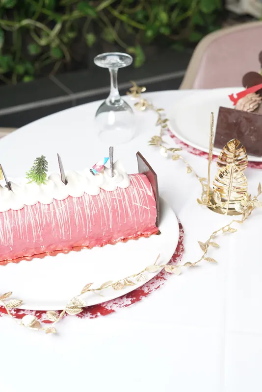 Part de bûche à la framboise sur assiette, décor de fêtes